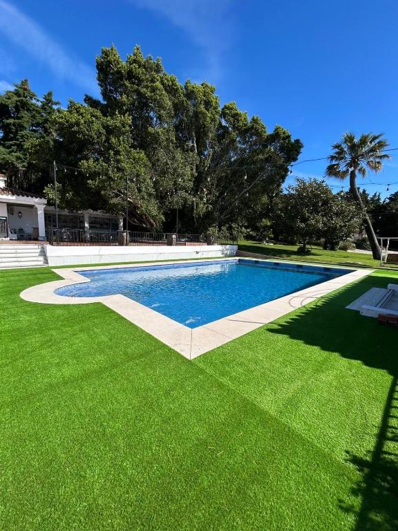 a swimming pool in a yard with green grass at Finca El Campo Villa privada con piscina y vistas a la naturaleza in Algeciras