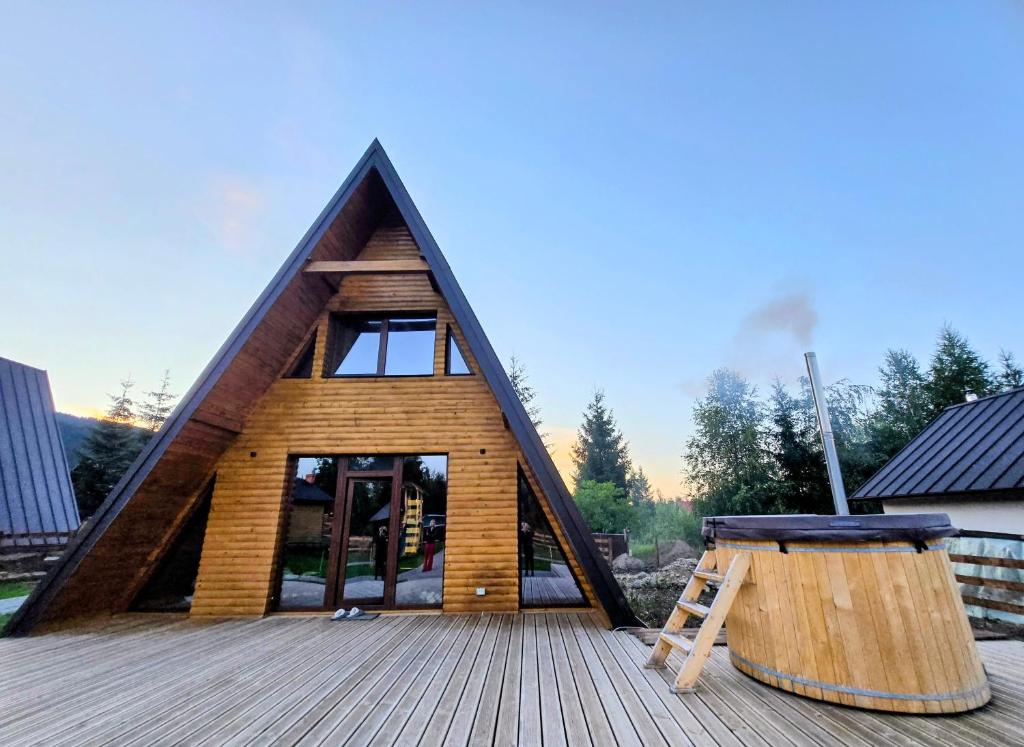 a frame house with a ladder on a deck at DB Forest Resort in Bucsin