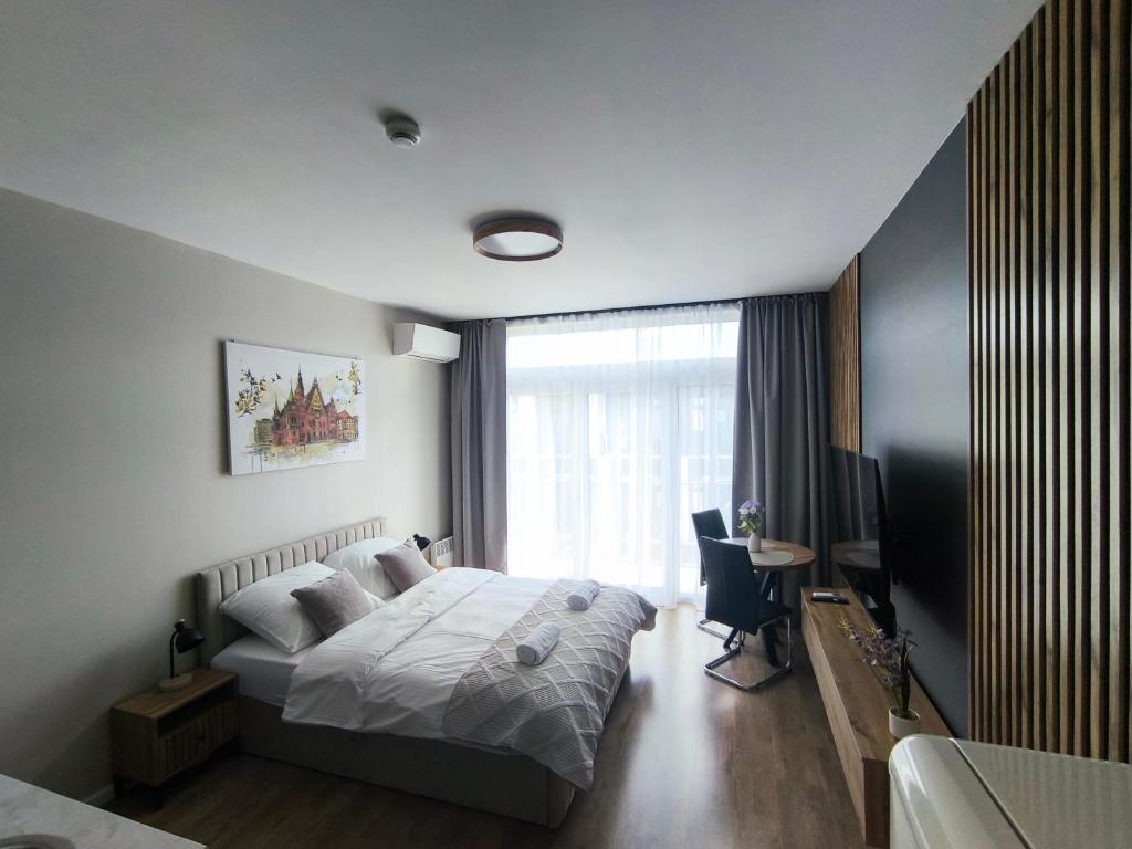 a bedroom with a bed and a desk and a window at DN Fly & Stay in Wrocław