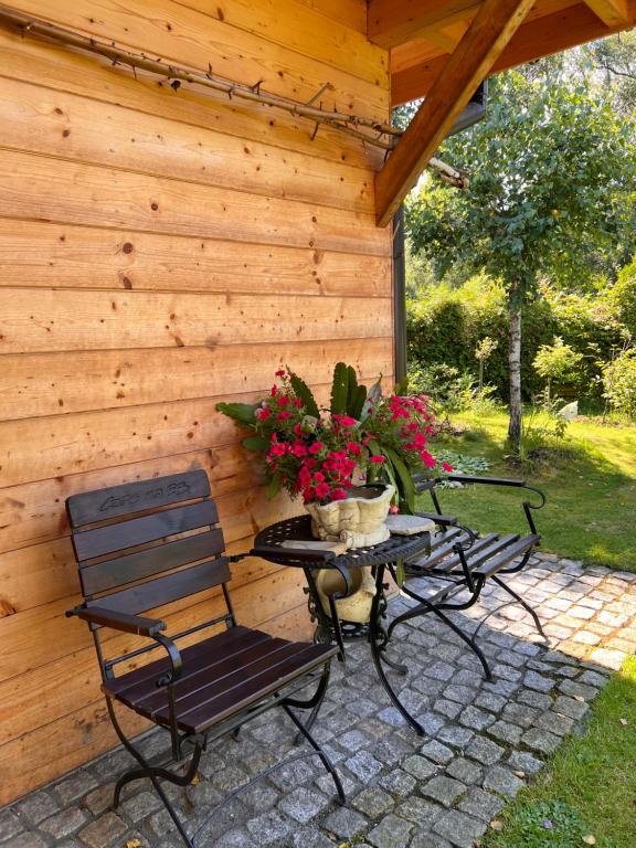 a patio with two chairs and a table with flowers at Przy ścieżce in Węgierska Górka