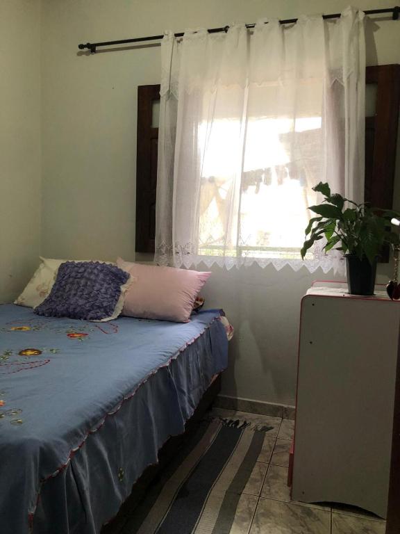 a bedroom with a bed and a window at Quarto Manjericão in Ibicoara