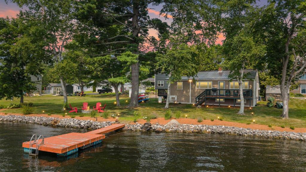 a house on the shore of a river with a dock at Cozy Keyes Cottage in Winthrop