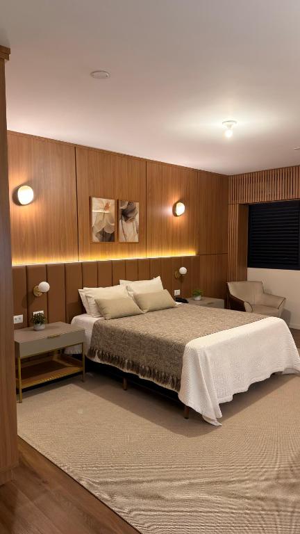 a bedroom with a large bed and wooden walls at Palace Hotel Três Poderes in Frutal