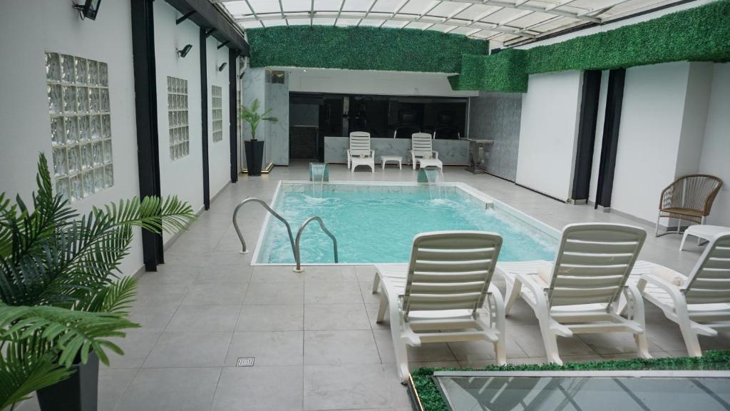 an indoor swimming pool with chairs and a table at Ker Recoleta Hotel in Buenos Aires