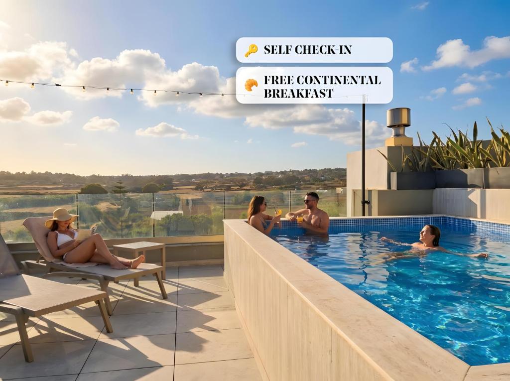 a group of people sitting in a swimming pool at Ta' Guzeppi Boutique Stays Near St Thomas Bay in Il-Maħsel