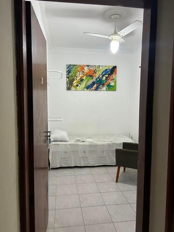 a bedroom with a bed and a ceiling fan at Quarto econômico e confortável in Hortolândia