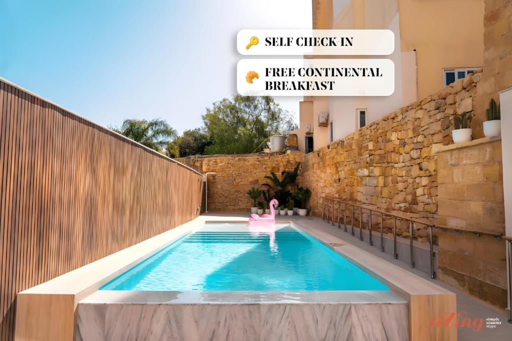 a swimming pool with a pink chair in a building at Spinola Stays St Julian's in St. Julianʼs