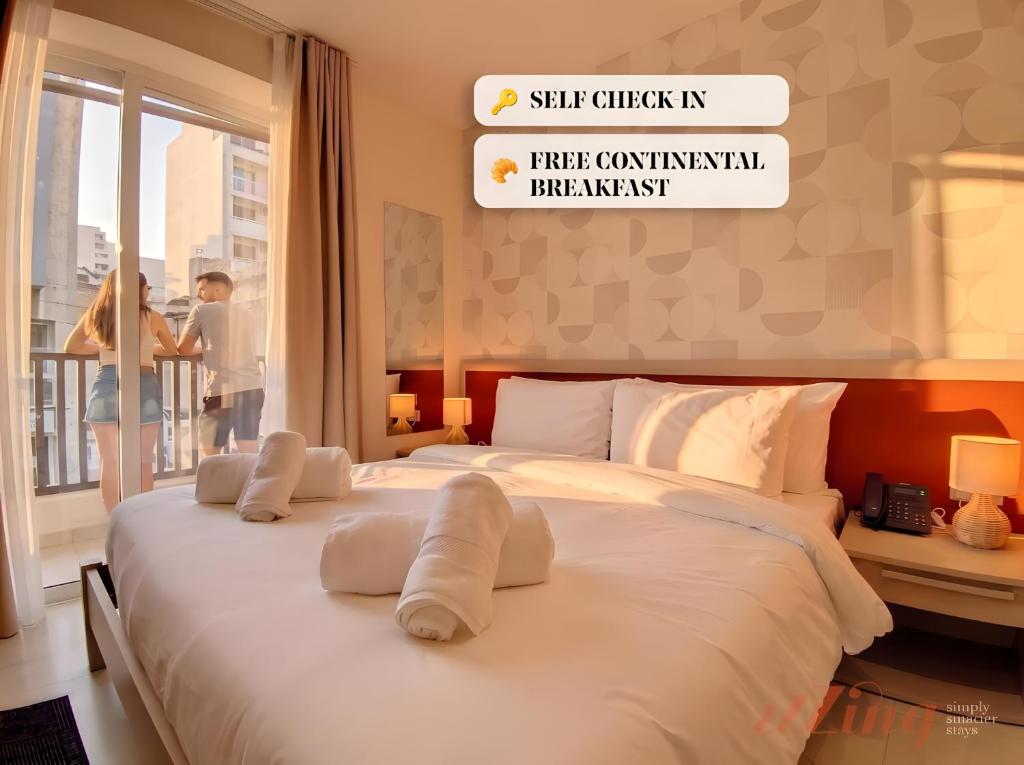 a bedroom with a large white bed with a window at Lepanto Guesthouse in Misraħ Il-Barrieri