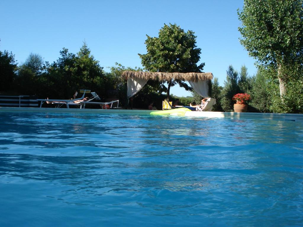 a woman sitting on a raft in a swimming pool at Agriturismo Materno in Radicondoli