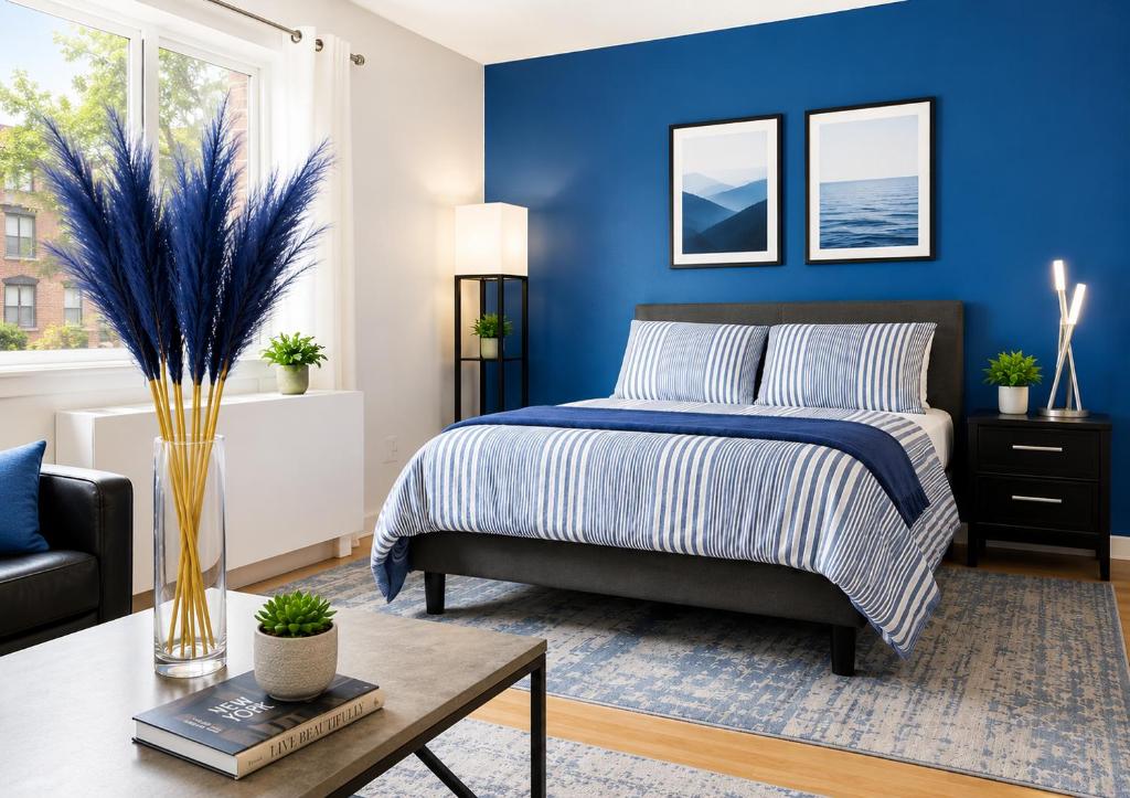 a blue bedroom with a bed and a table at Studio apart Time Square in New York
