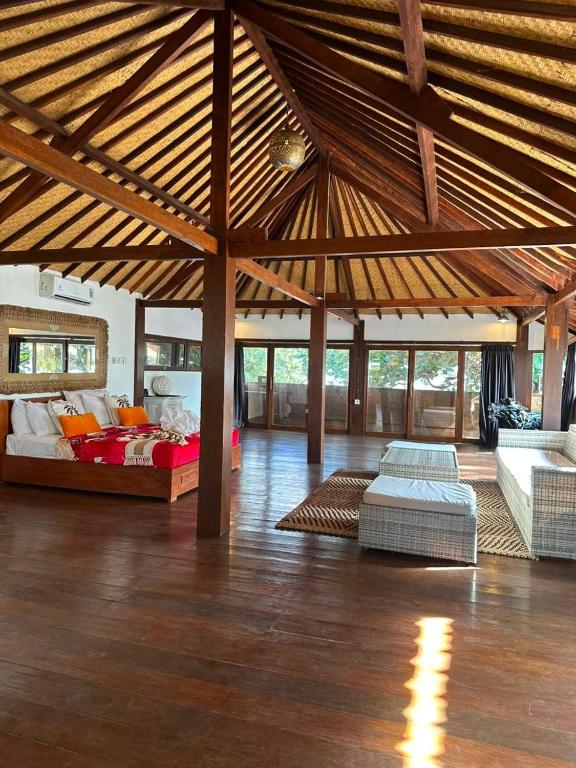 a large room with two beds and a couch at My happy place loft gili air in Gili Islands
