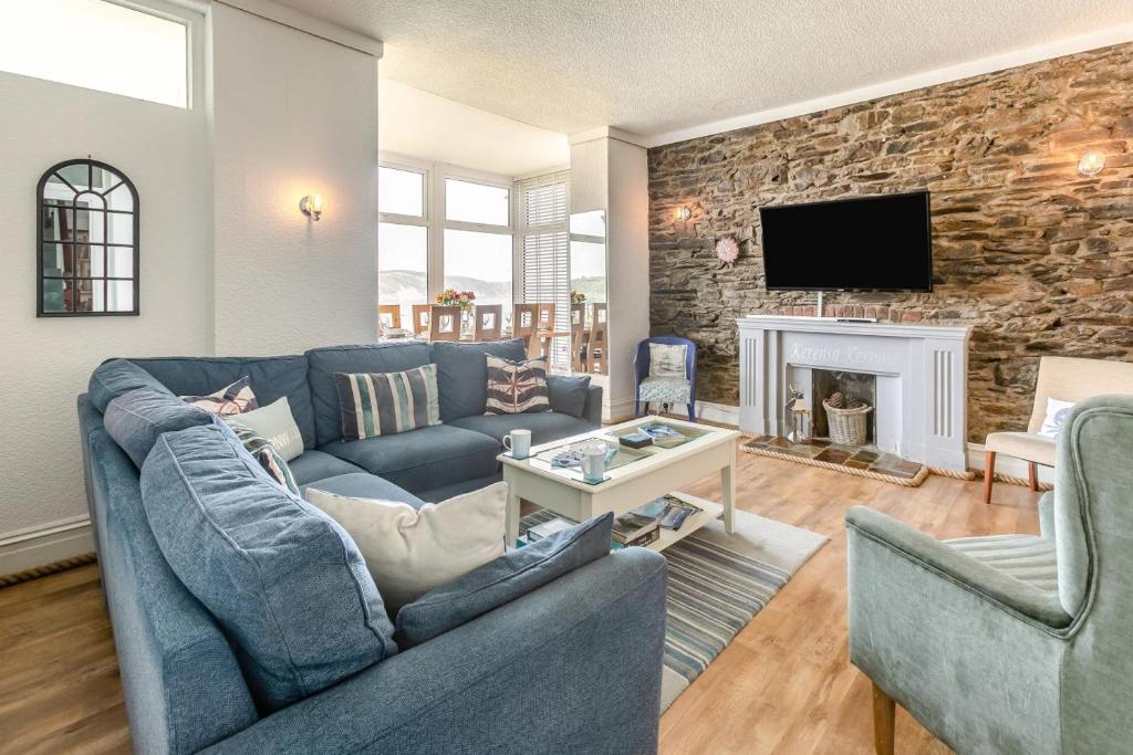 a living room with a blue couch and a stone wall at 4 Bed in Looe oc-l30051 in Looe
