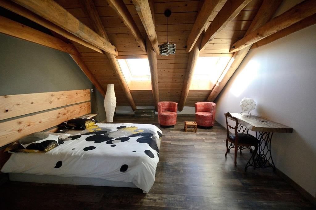 a bedroom with a bed and a table and chairs at La Grange de l'Ardeyrol in Saint-Clément