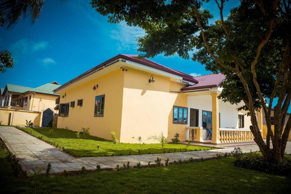 a house with a green lawn in front of it at The Vicarage in Lashibi