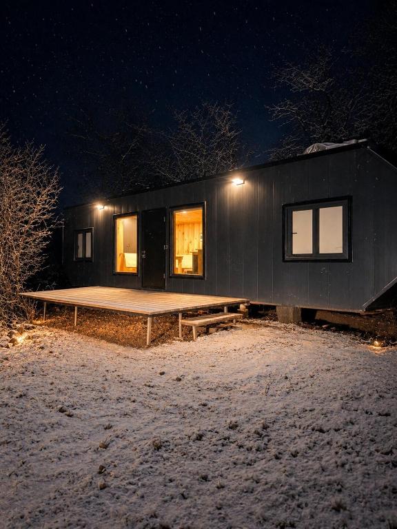 a small black house in the snow at night at Onix in Las Trancas