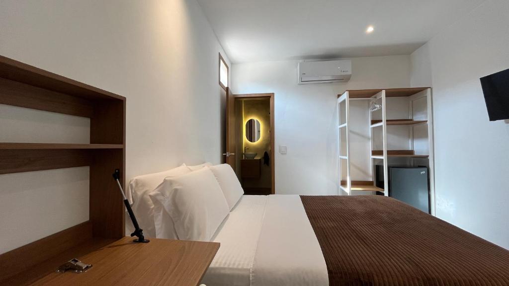 a bedroom with a bed and a desk and shelves at Casa Celisa in Cali
