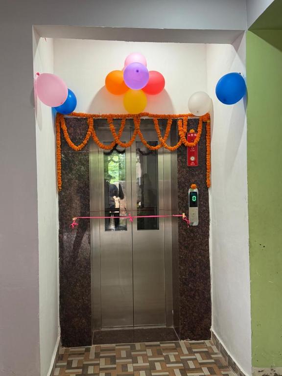 a hallway with an elevator with a bunch of balloons at Prakash Bhawan in Darbhanga