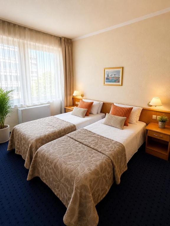 a hotel room with two beds and a window at Hotel Kreuzplatz Gießen Zentrum in Gießen