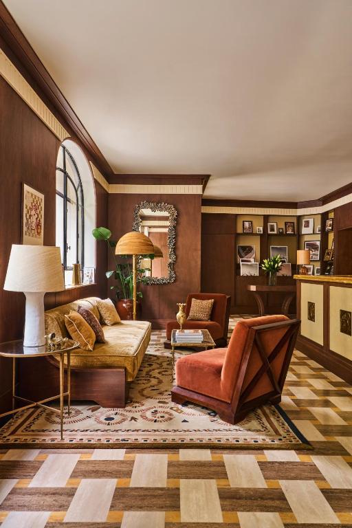 a living room with a couch and a chair at Hôtel Madison in Paris