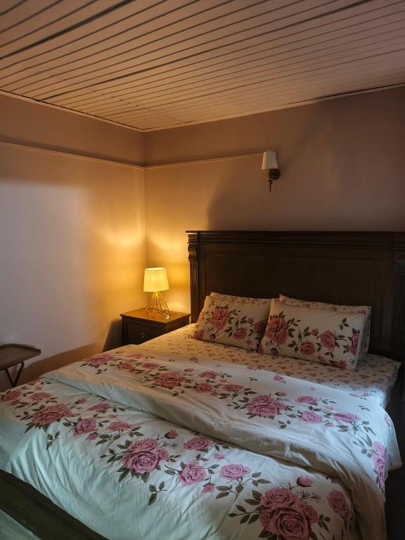 a bedroom with a large bed with flowers on it at The Jasmine House - Ayubia in Ayubia