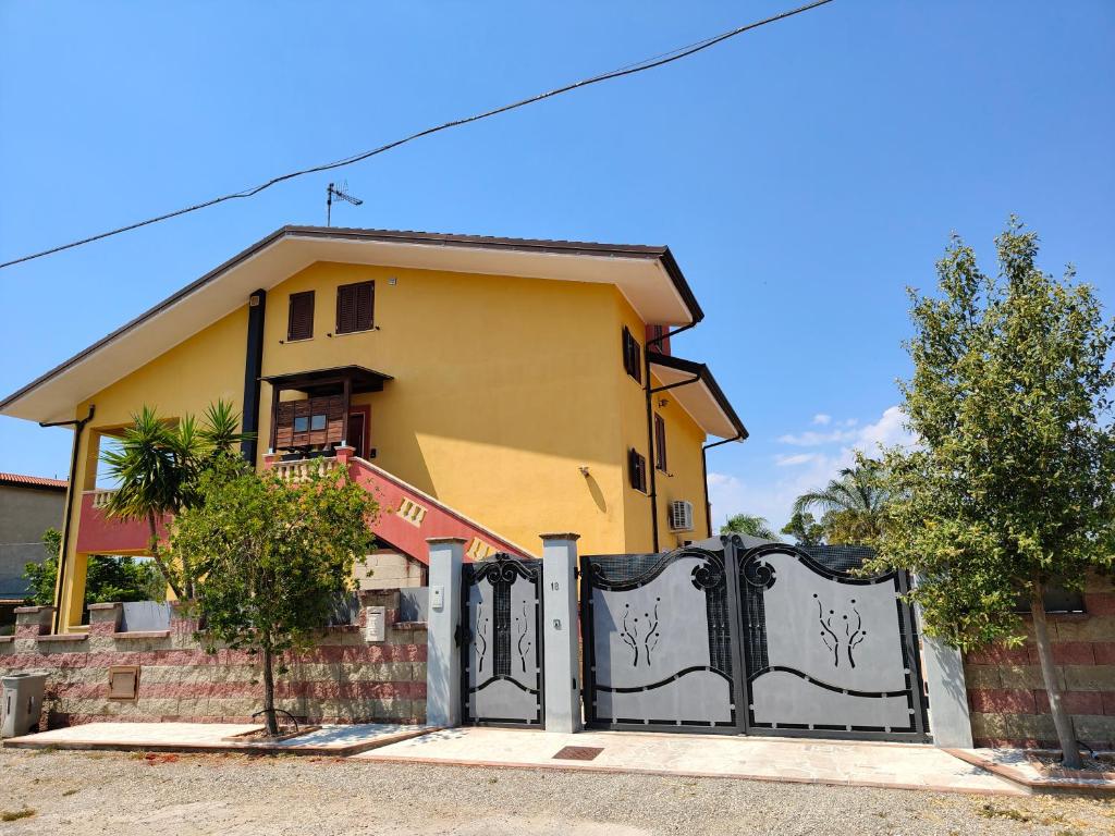a yellow house with a gate in front of it at La Terrazza in Carrao