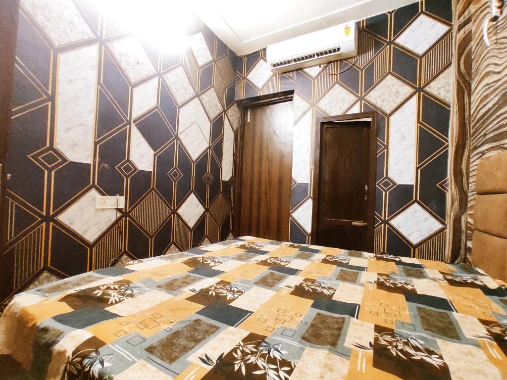 a bedroom with a bed with a tiled wall at ML HOMESTAYS - For Family, Students, Parents, Couples in Phagwāra