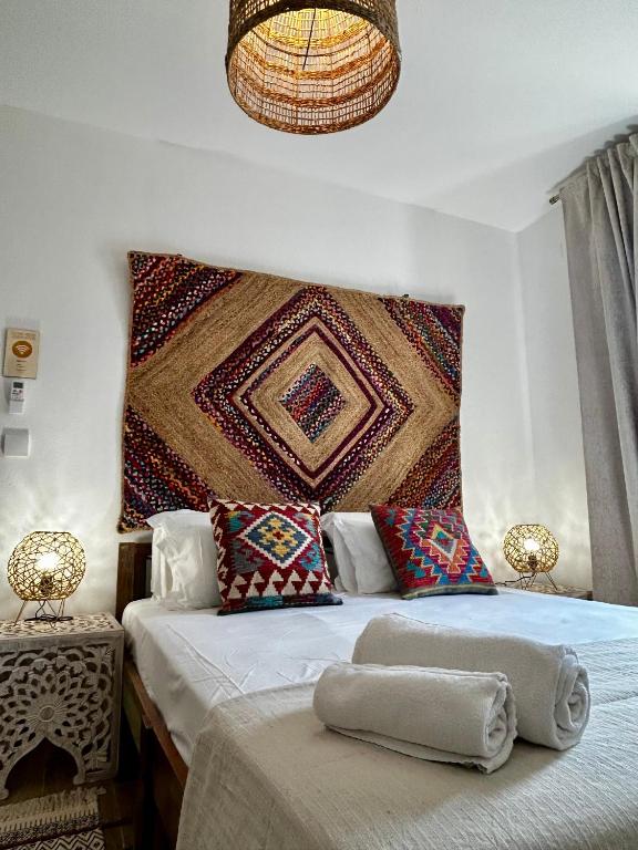 a bedroom with a bed with two pillows and a wall at Ocean House Alentejo in Porto Covo