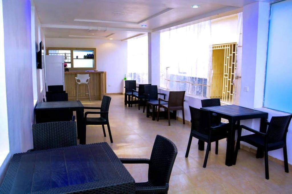 a dining room with tables and chairs in a restaurant at Bgl suites in Barakin Akawo