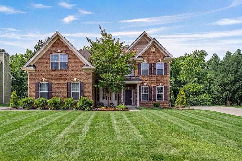 a brick house with a large lawn at The Blue Crown Manor at Concord Estates in Concord