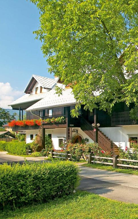 a large house with a porch and a tree at House Klasika - Adults Only in Bled