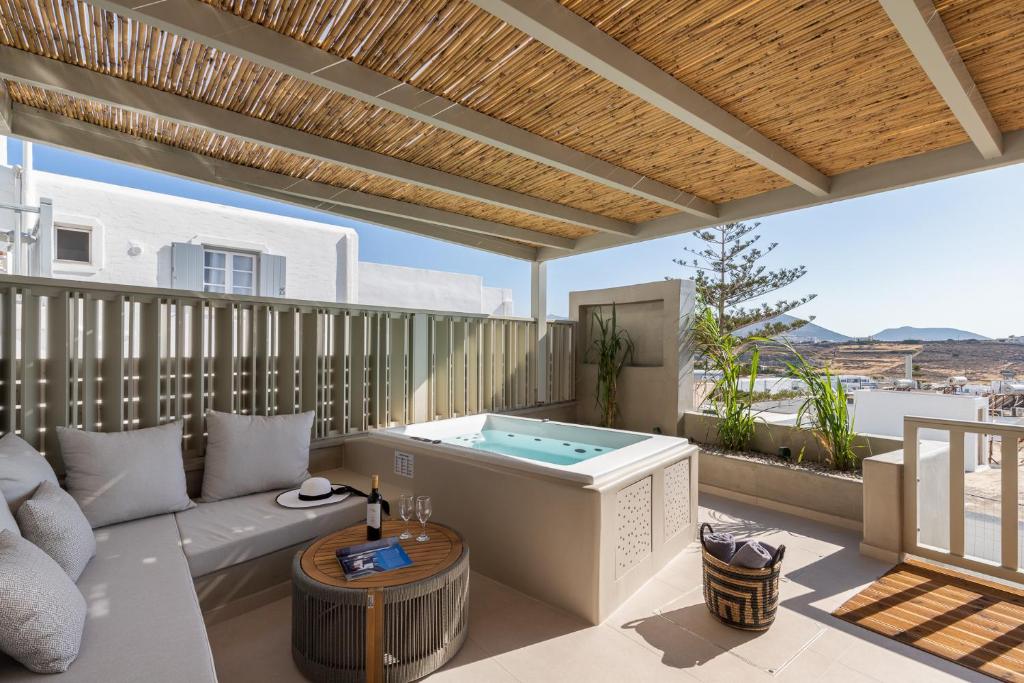 a patio with a hot tub on a deck at Clementina Hill in Naousa
