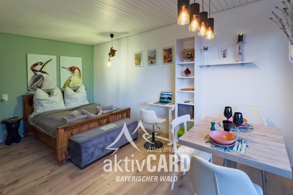 a living room with a bed and a dining table at Am Silberbergblick in Bodenmais