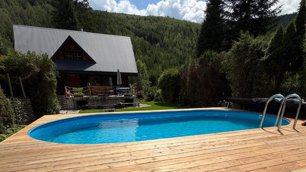 a swimming pool on a wooden deck next to a house at Ujsoły Chill House w Beskidach, Beskid Żywiecki in Ujsoły