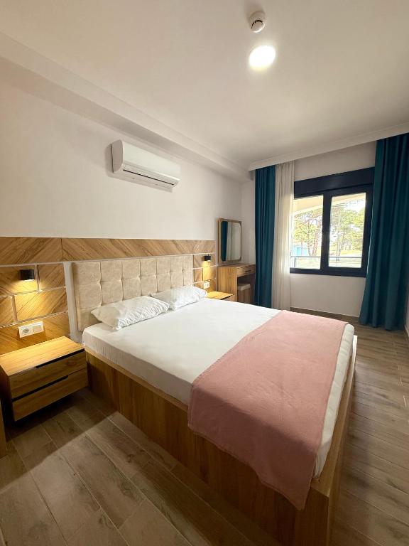 a bedroom with a large bed and a window at ÇAMLIK APART in Ayvalık