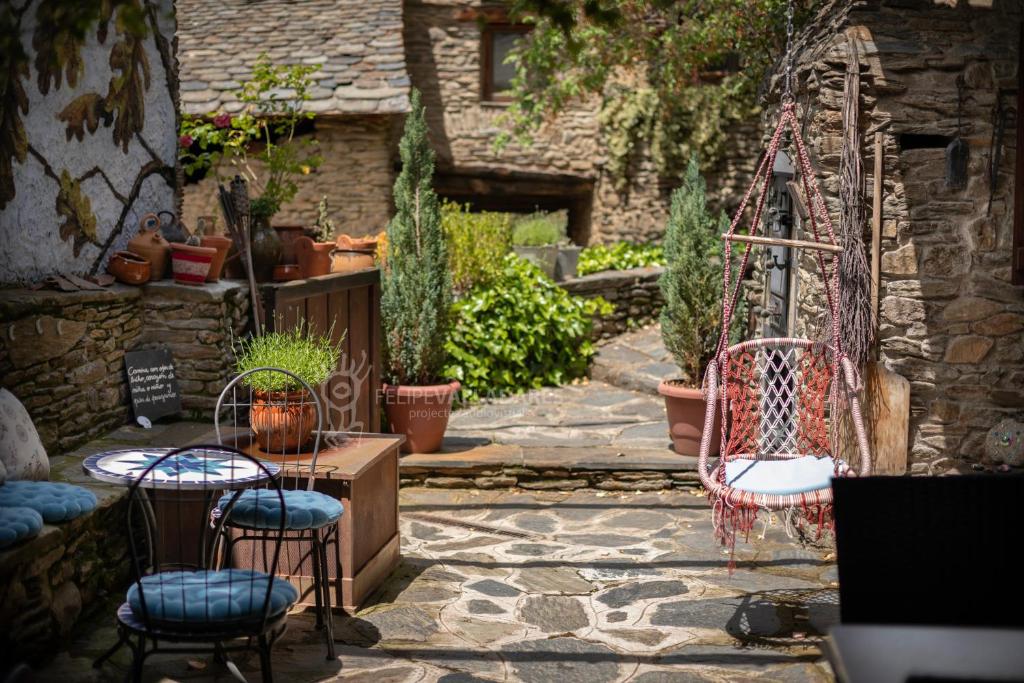 a stone patio with two chairs and a swing at La Coberta-Lo Paller del Coc in Rialp