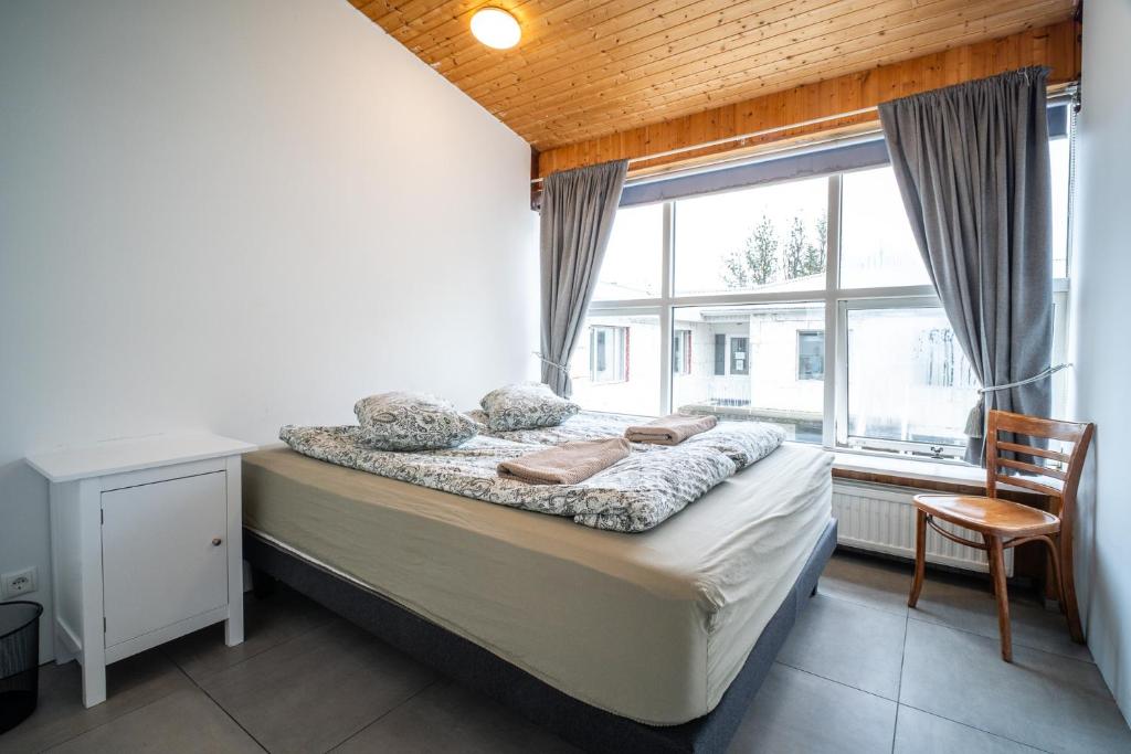 ein Schlafzimmer mit Bett, Schreibtisch und Fenster in der Unterkunft Selfoss Hostel in Selfoss
