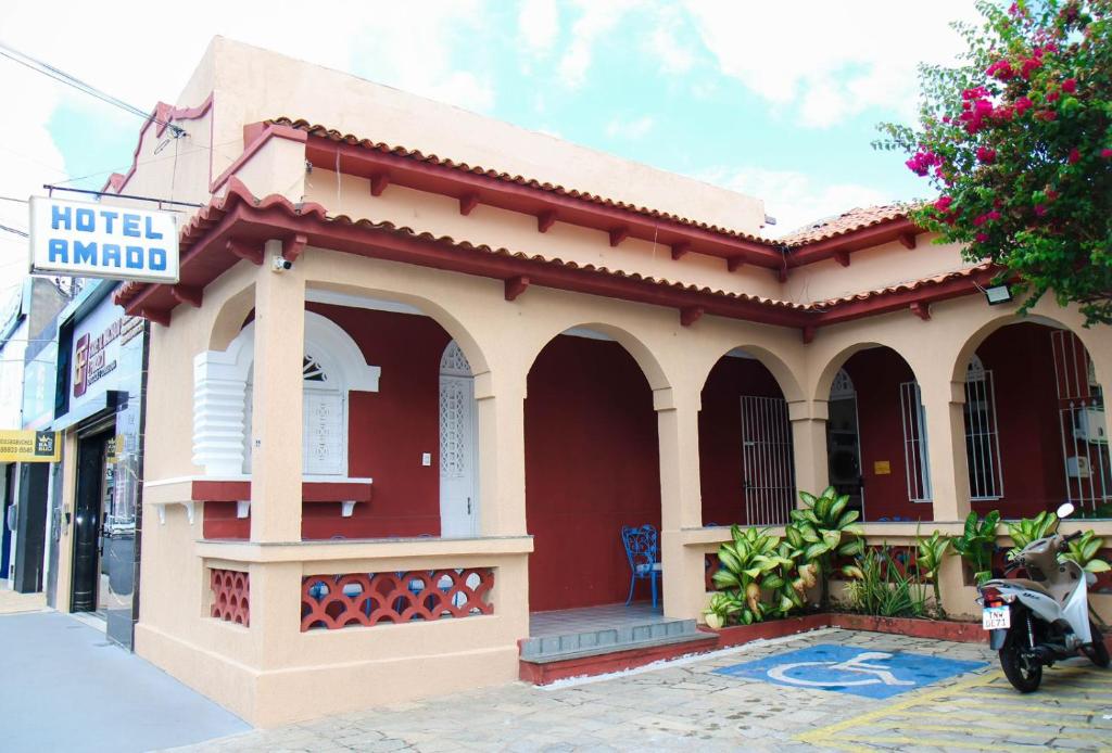 a small red and white building on a street at Hotel Amado in Aracaju