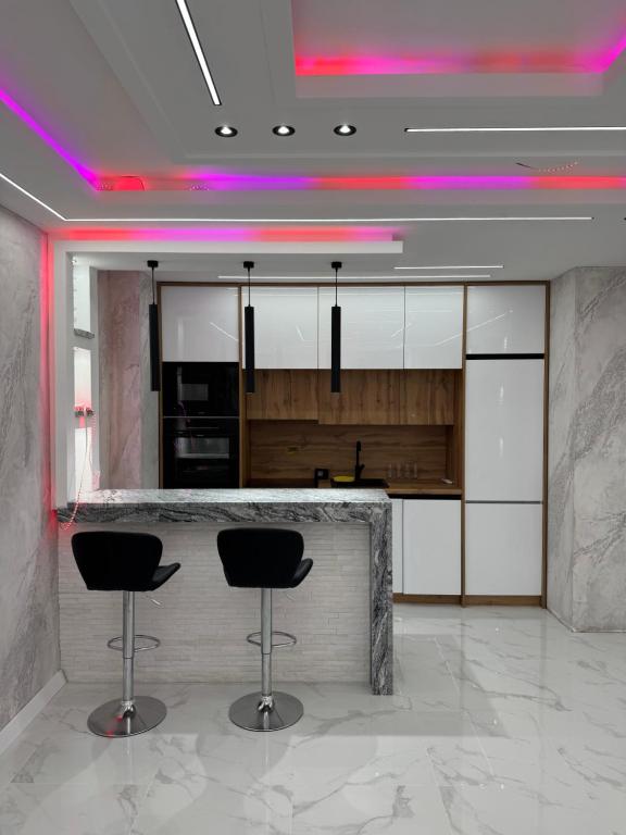 a kitchen with two bar stools in a room at NelaLux 2 in Bratunac