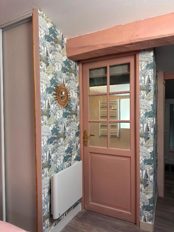 a red door in a room with a wall at La chambre de Joséphine in Royan