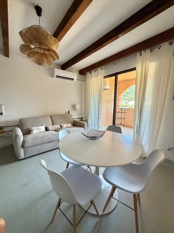 a living room with a table and chairs and a couch at Stella-Bianca in Sagone