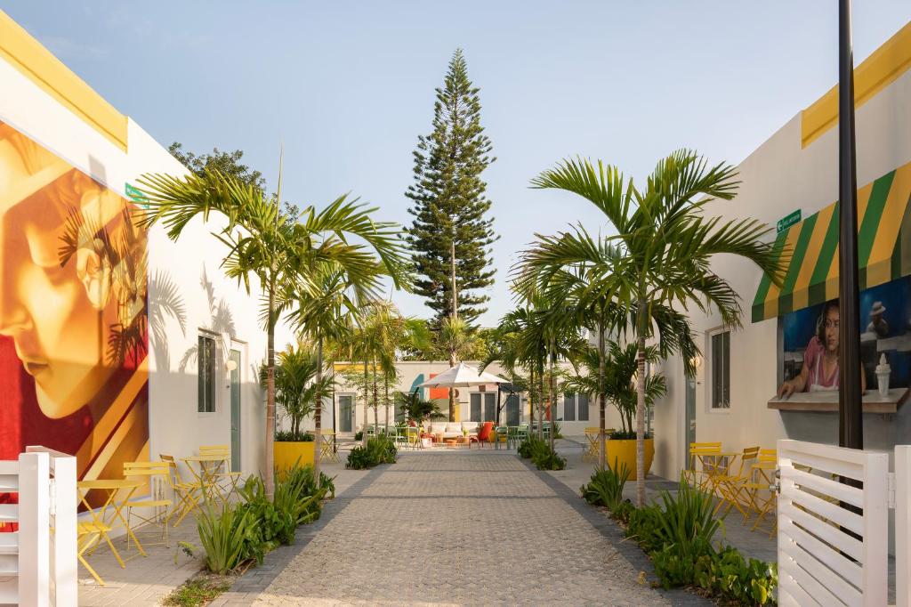 a street in a resort with palm trees and chairs at El Jardin Inn in Miami