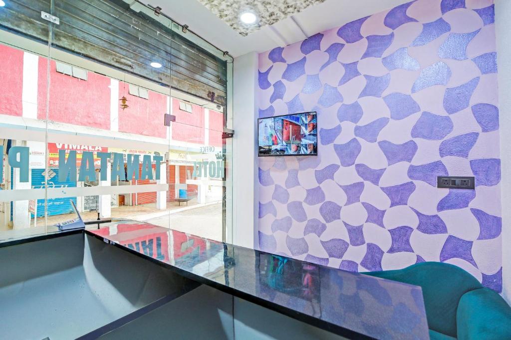 a glass counter in a room with a wall at Hotel O Tanatan Premium in Bhopal