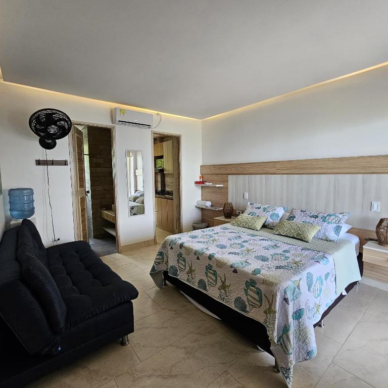a bedroom with a bed and a chair in it at Aves de Laguna Beach in Tierralta