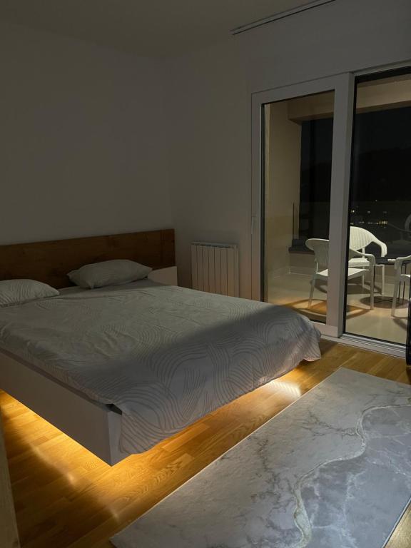 a bedroom with a bed and a view of a balcony at Tuzla Tower in Ši Selo