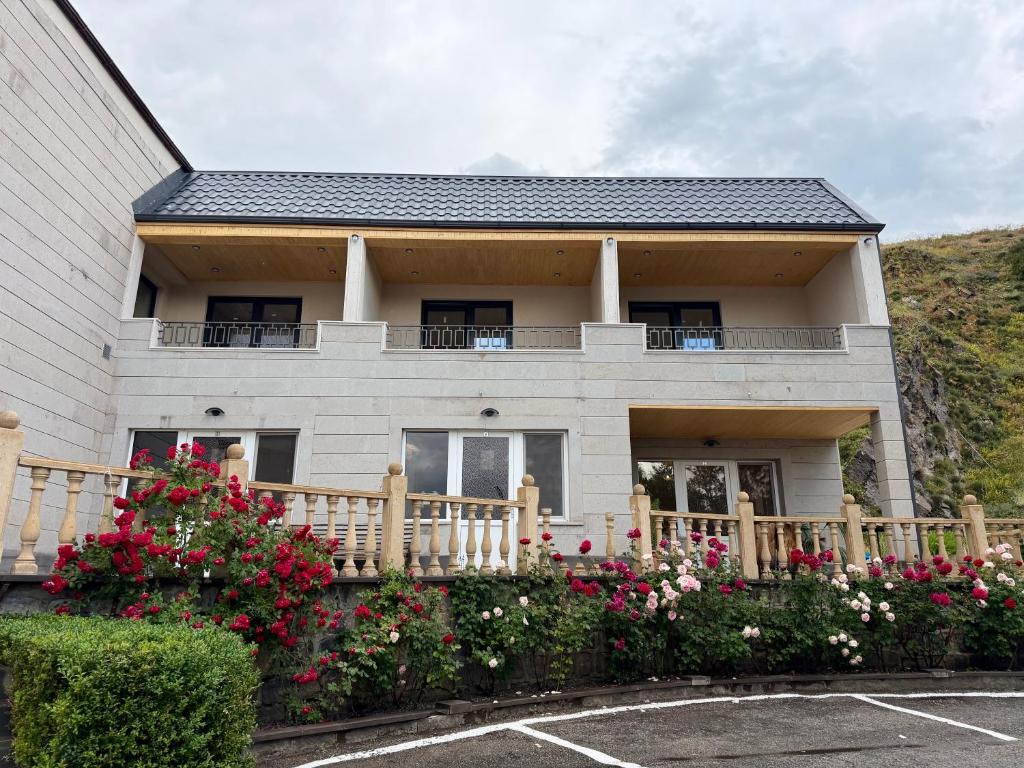a white house with flowers in a parking lot at Sevanavanq Inn Hotel in Sevan