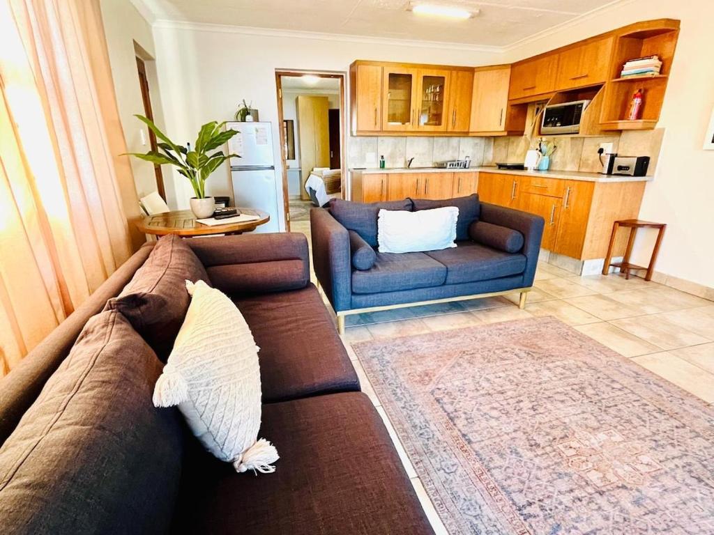 a living room with a couch and a kitchen at Lieben Gast in De Kelders