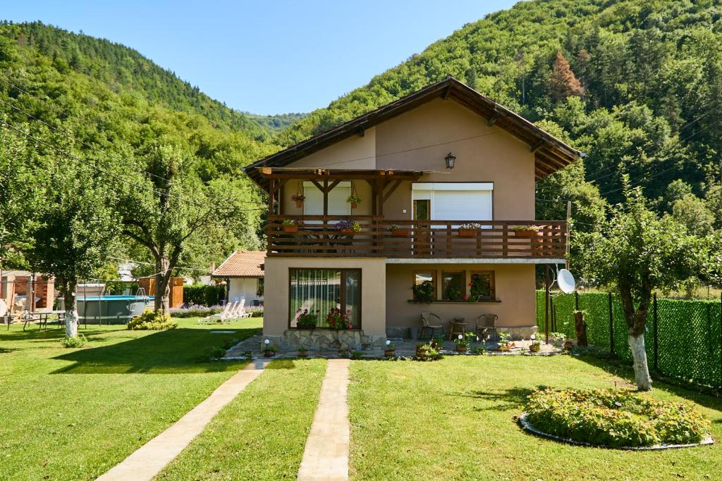 a house with a balcony on top of a yard at Вила Якимови in Ribarica