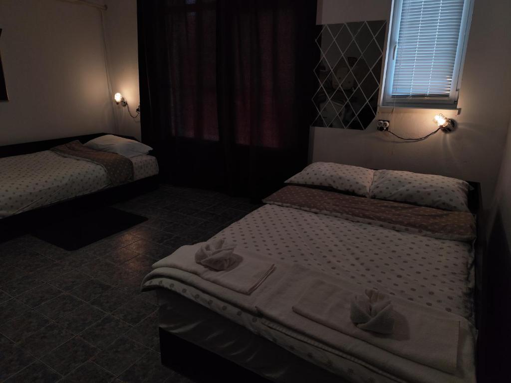 a room with two beds and a window in it at Стая за гости При Валко in Belogradchik