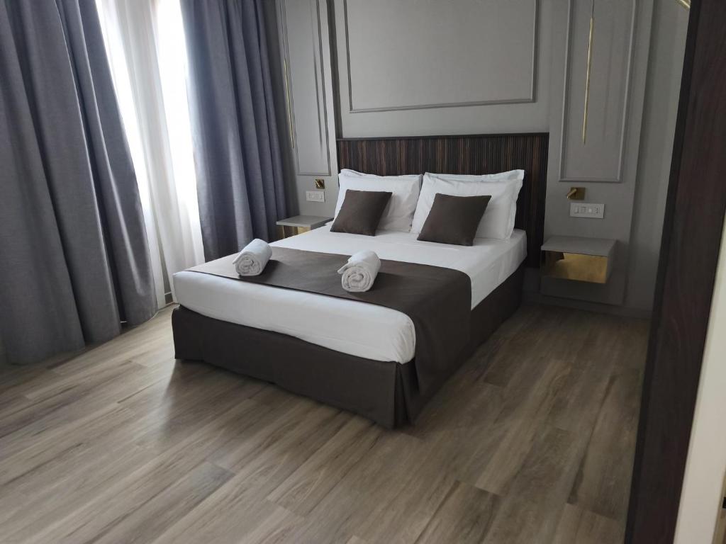 a bedroom with a large bed with white sheets and pillows at Hotel Serafino in Padova