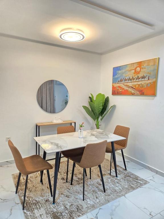 a dining room with a white table and chairs at Résidences Laurence in Bingerville
